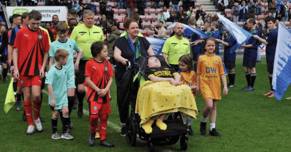 Joseph's goal charity supporters stood on the football pitch with Emma and Joe Kendrick