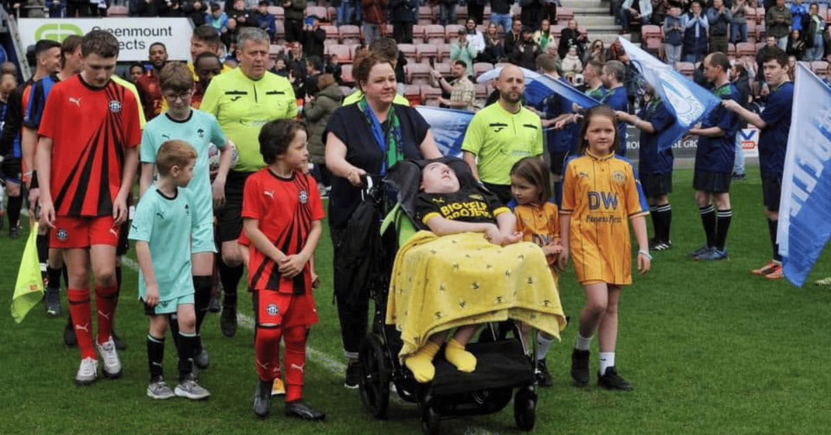 Joseph's goal charity supporters stood on the football pitch with Emma and Joe Kendrick